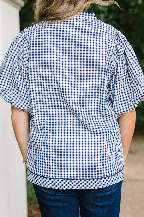 Plus size navy gingham top with a flowy fit, V-neckline, and short flutter sleeves.