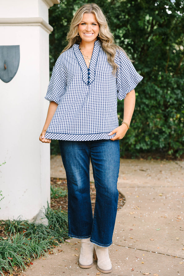 Plus size navy gingham top with a flowy fit, V-neckline, and short flutter sleeves.