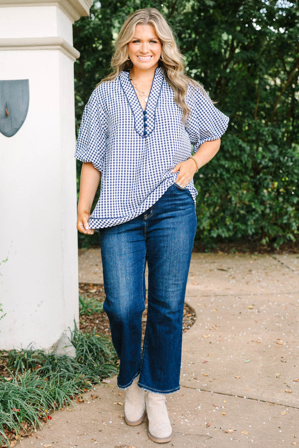 Plus size navy gingham top with a flowy fit, V-neckline, and short flutter sleeves.