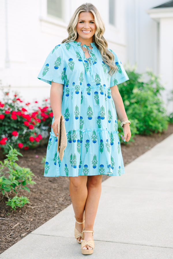 Chic Soul plus size clothing, light blue tiered knee length dress with a dark blue and green floral pattern as well as two bows that tie  on the across the v-neckline 