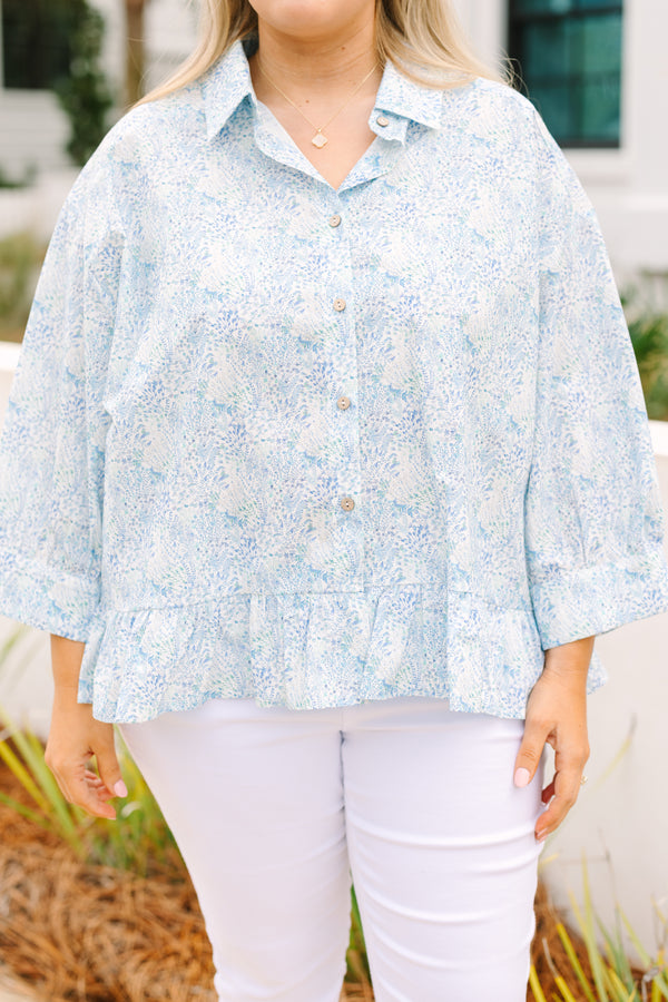 Chic Soul plus size clothing, cerulean top with long sleeves and buttons going down the center of the top as well as a ruffle detail at the bottom of the top and a thin floral pattern throughout 