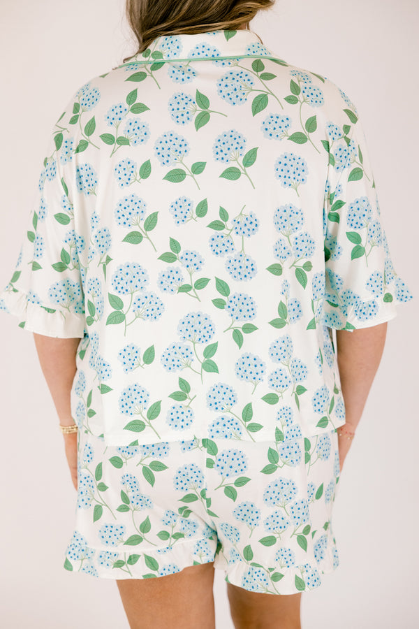 Plus Size short-sleeve pajama set with blue hydrangea print, ruffle trim, and button-down front.