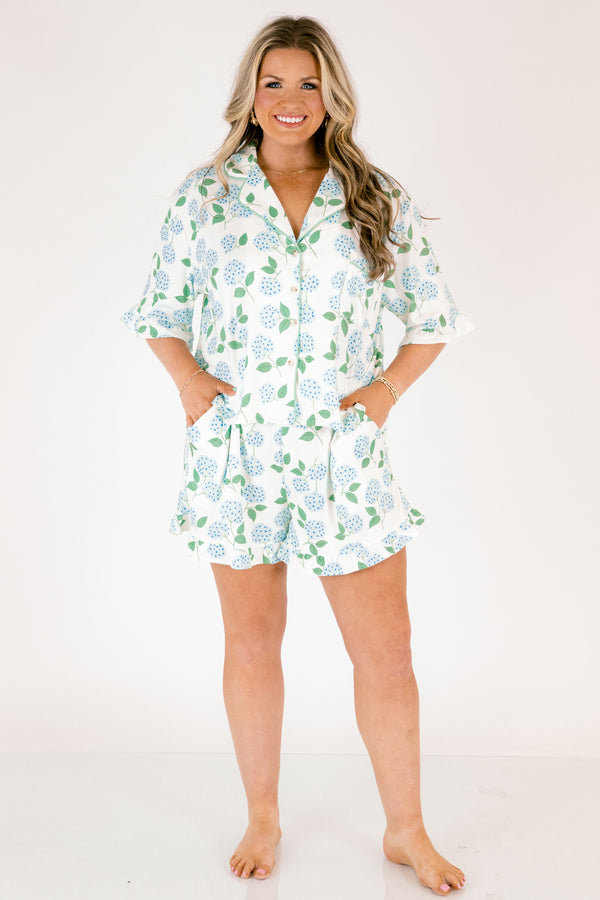 Plus Size short-sleeve pajama set with blue hydrangea print, ruffle trim, and button-down front.