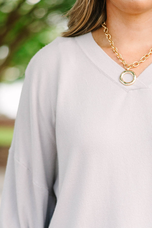 Plus size taupe-gray V-neck sweater with a relaxed, flowy fit and soft, stretchy fabric.
