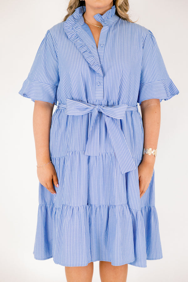 Chic Soul plus size clothing, blue striped tiered midi dress with short sleeves that have a ruffle at the end of them as well as a ruffle detail going around the collar and down the buttons on the chest and a belt that ties into a bow that goes around the waist