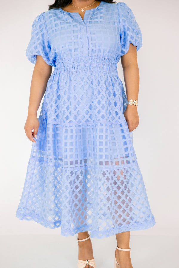 Chic Soul plus size clothing, pastel blue maxi dress with buttons going down to the chest and bubble sleeves as well as a sheer overlay going over the whole dress that has a plaid pattern 