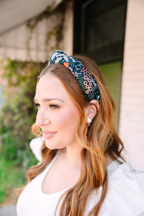Chic Soul plus size clothing, black headband with a knot detail on the top of the headband and a multi color floral pattern throughout the headband 