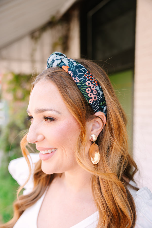 Chic Soul plus size clothing, black headband with a knot detail on the top of the headband and a multi color floral pattern throughout the headband 