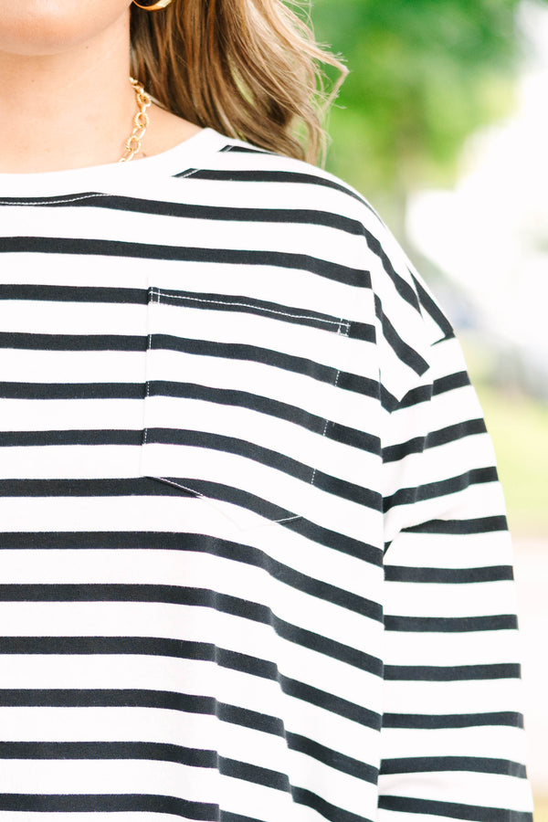 Plus size woman in a flowy white and black striped long sleeve cotton top with a front pocket.