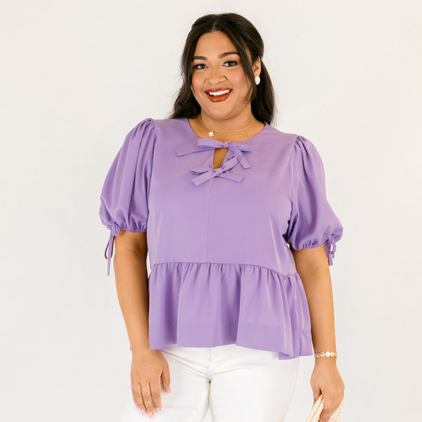 Plus Size purple peplum babydoll top with bow neckline details and elastic puff sleeves.