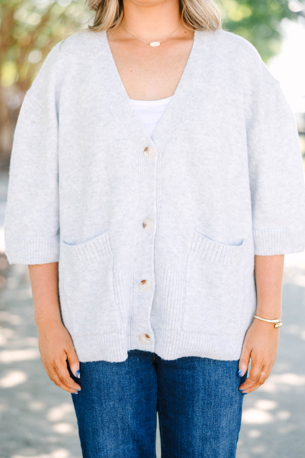 Plus Size gray v-neck cardigan with short sleeves, front patch pockets, and tortoise shell buttons.