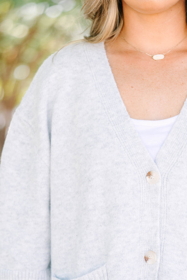 Plus Size gray v-neck cardigan with short sleeves, front patch pockets, and tortoise shell buttons.