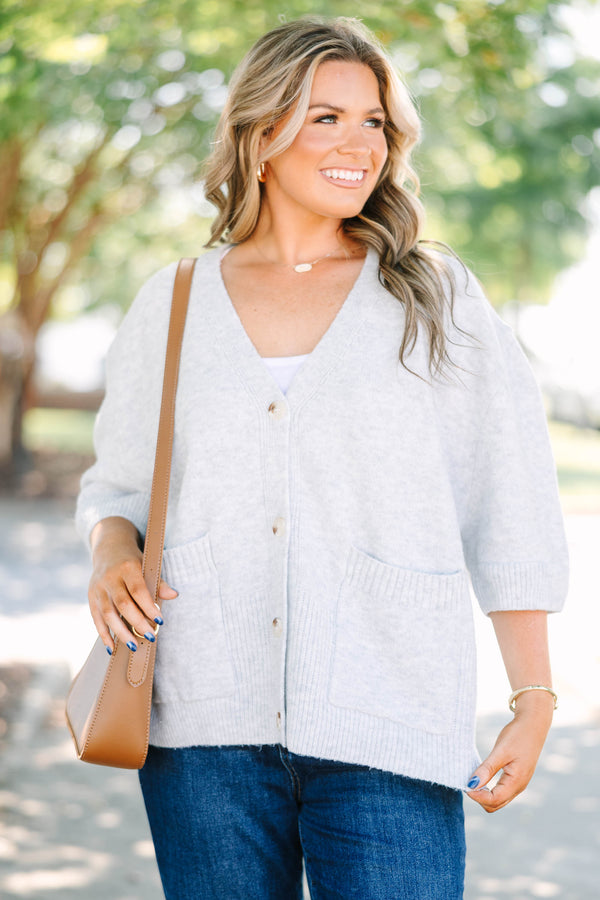 Plus Size gray v-neck cardigan with short sleeves, front patch pockets, and tortoise shell buttons.