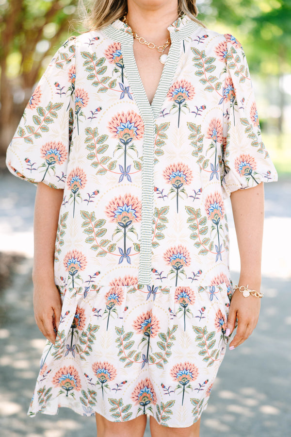 Plus size cream floral mini dress with a flowy fit, puff sleeves, and a striped V-neckline.