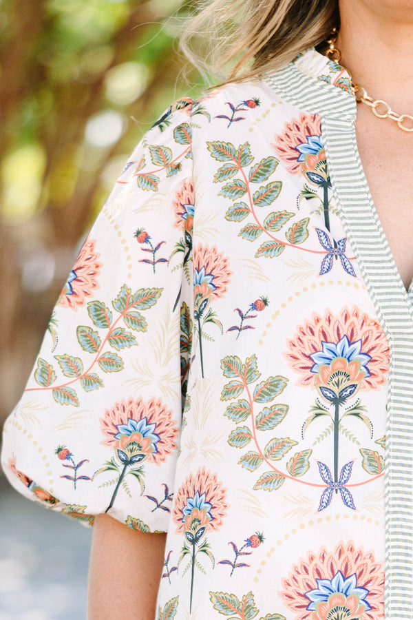 Plus size cream floral mini dress with a flowy fit, puff sleeves, and a striped V-neckline.