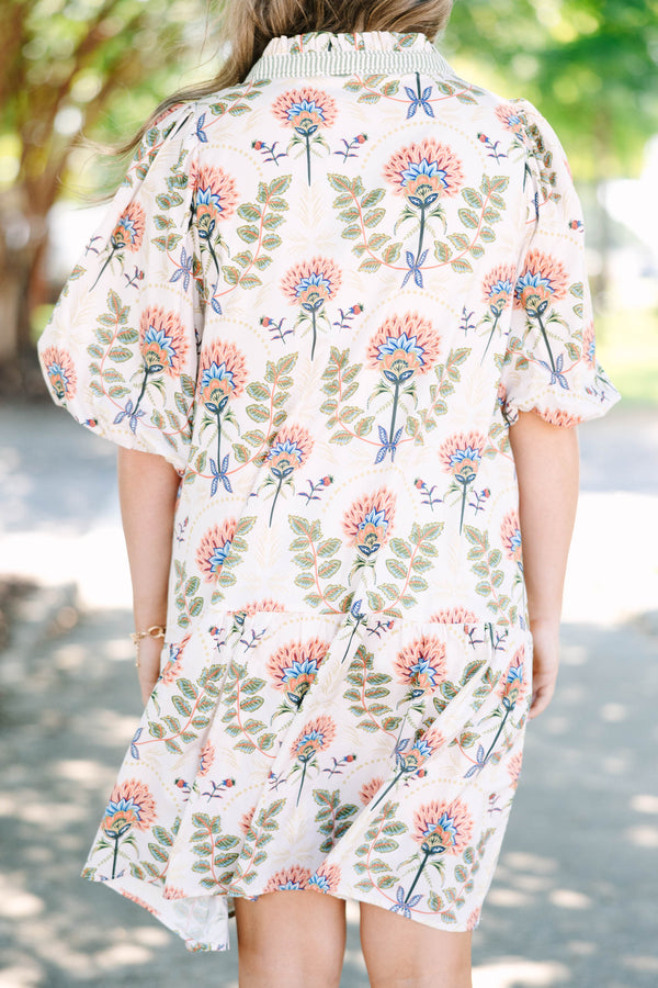Plus size cream floral mini dress with a flowy fit, puff sleeves, and a striped V-neckline.