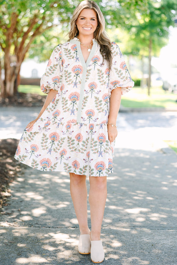 Plus size cream floral mini dress with a flowy fit, puff sleeves, and a striped V-neckline.
