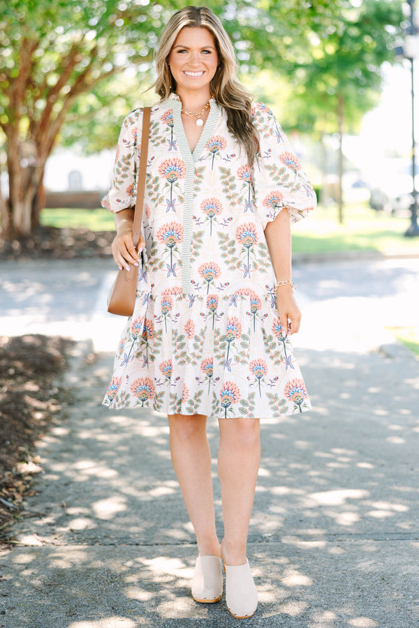 Plus size cream floral mini dress with a flowy fit, puff sleeves, and a striped V-neckline.