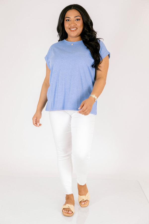 Plus Size heather ocean blue crew neck tee with cuffed short sleeves and white pants.
