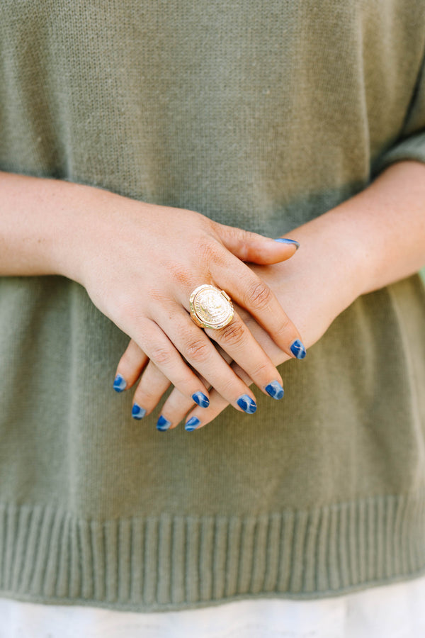 Close-up of a hand wearing the gold Saddle Creek coin ring