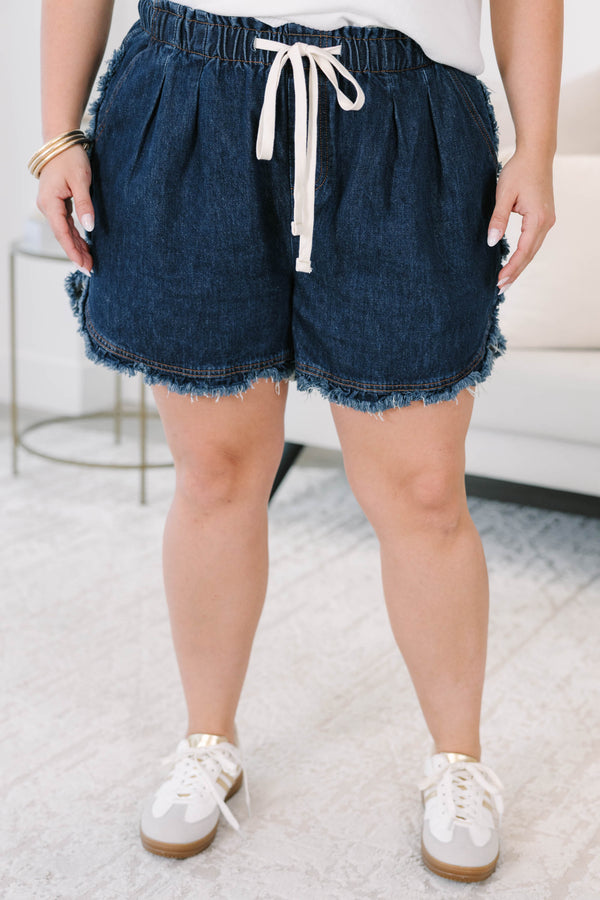 Plus size dark wash denim shorts with a drawstring elastic waist and frayed hem for a flowy fit.