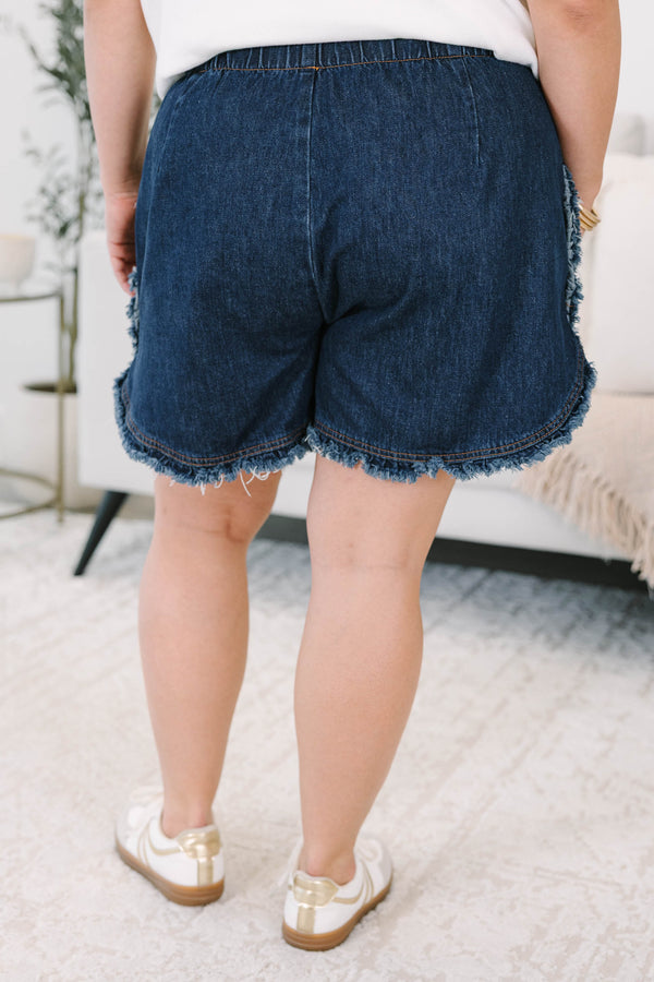Plus size dark wash denim shorts with a drawstring elastic waist and frayed hem for a flowy fit.