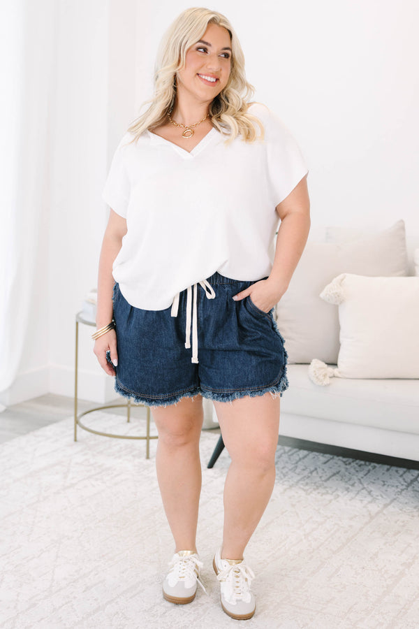 Plus size dark wash denim shorts with a drawstring elastic waist and frayed hem for a flowy fit.