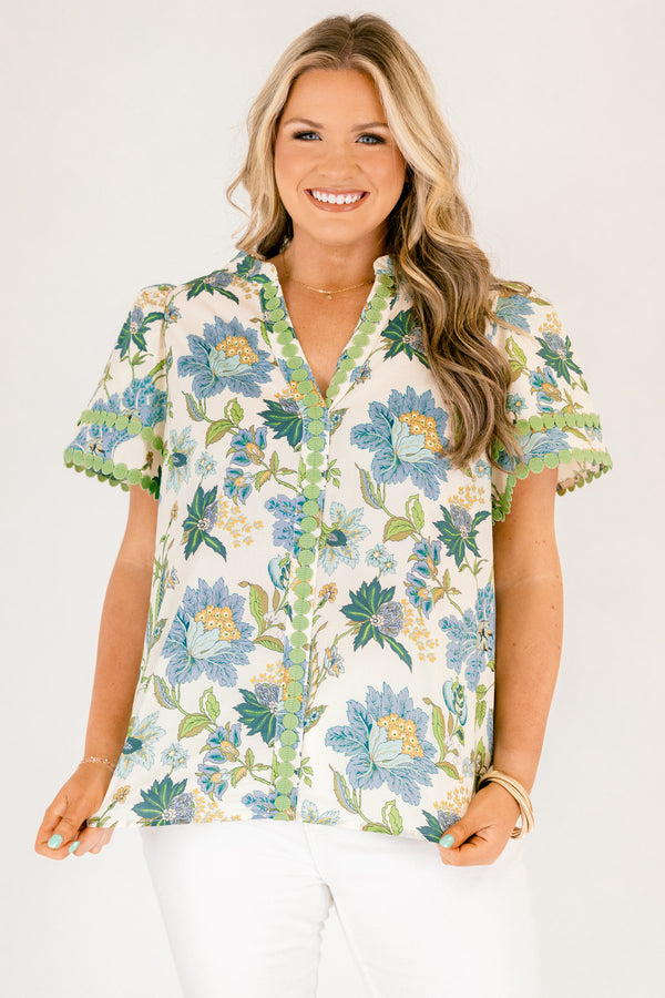 Chic Soul plus size clothing, white short sleeve top with blue and green tropical floral pattern and green dot embroidery along the hems of the sleeves and bordering the v-neckline going down the middle of the top