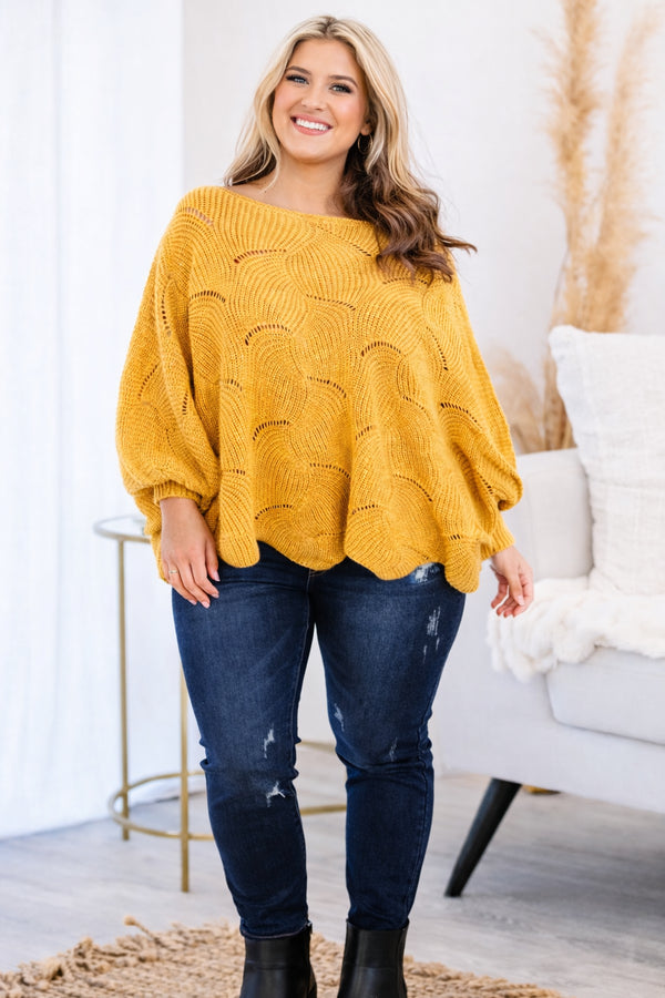 Plus Size mustard yellow poncho-style sweater with a textured wave pattern and dark wash jeans.