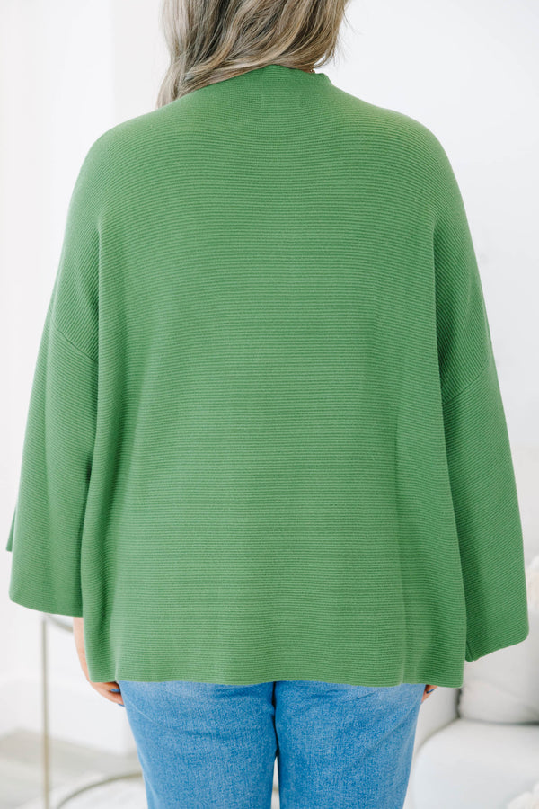 Plus size olive green ribbed sweater with a flowy oversized fit, mock neck, and wide bell sleeves.