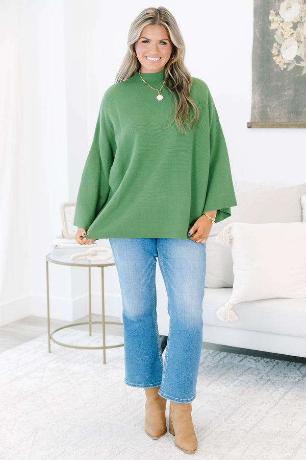 Plus size olive green ribbed sweater with a flowy oversized fit, mock neck, and wide bell sleeves.