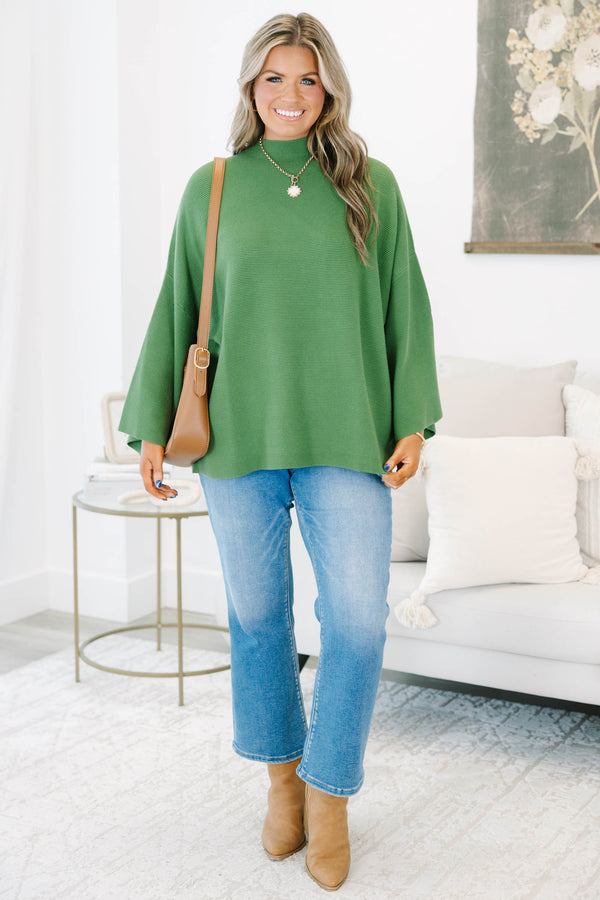Plus size olive green ribbed sweater with a flowy oversized fit, mock neck, and wide bell sleeves.