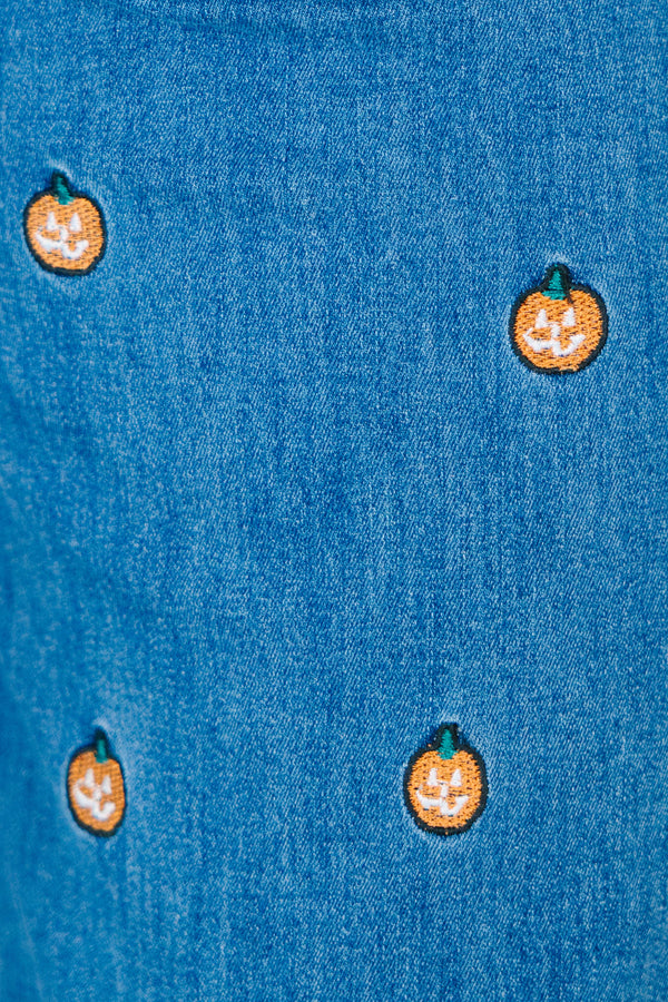 Plus size wide leg blue denim jeans with all-over pumpkin embroidery and a raw hem.