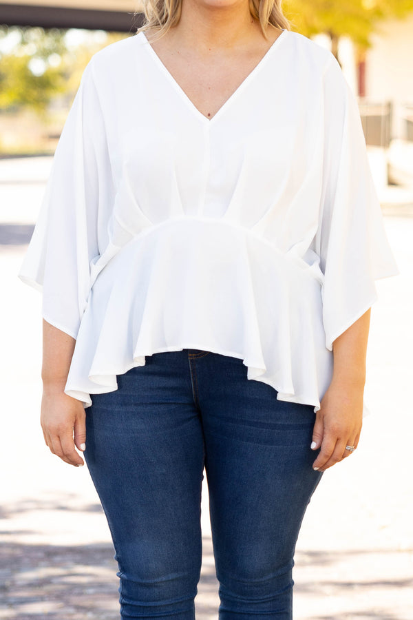 Plus Size ivory flowy blouse with batwing sleeves and a v-neckline paired with dark wash jeans.