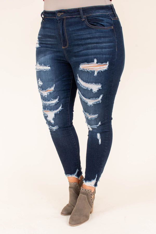 Plus Size dark wash skinny jeans with heavy distressing, ripped knees, and frayed hems.