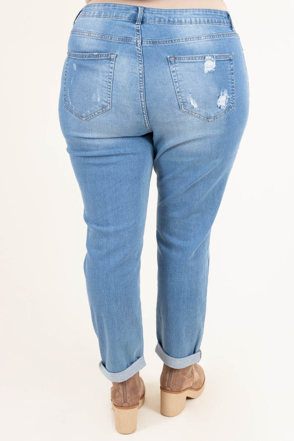 Plus Size light blue distressed jeans with a stretchy fit and cuffed hems.