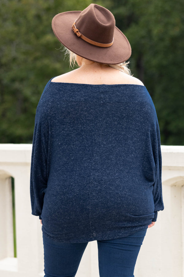 Plus Size navy blue long sleeve top with a boat neckline and relaxed fit paired with dark jeans.